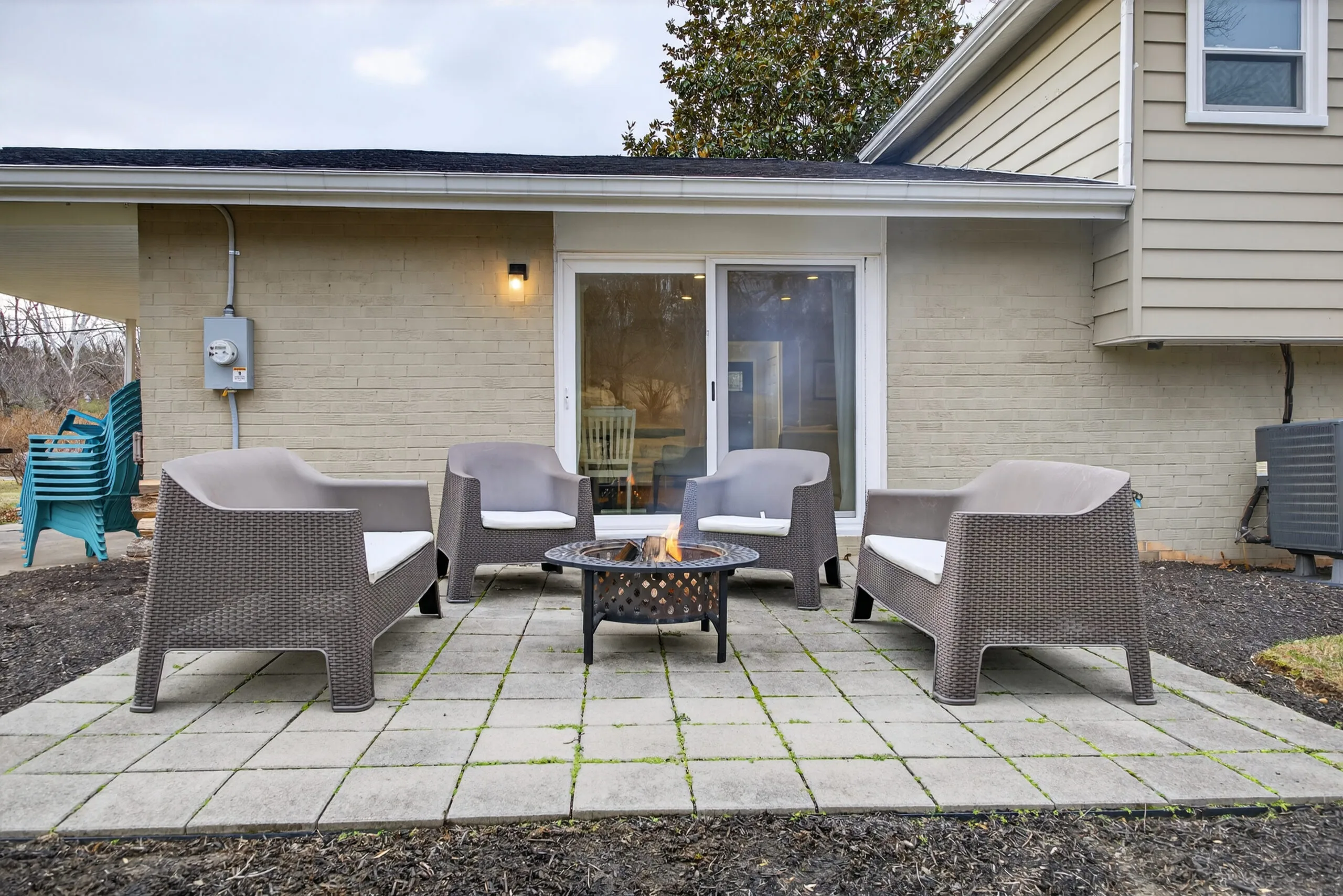 Outdoor patio lounge with armchairs and a fire pit at a premium vacation rental.