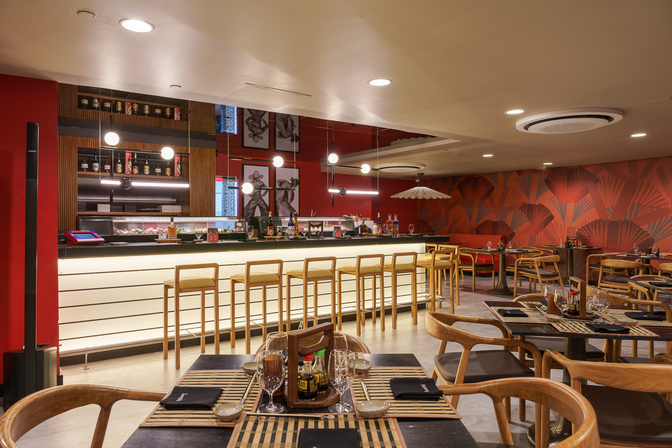 Interior de restaurante moderno con barra y asientos de madera.