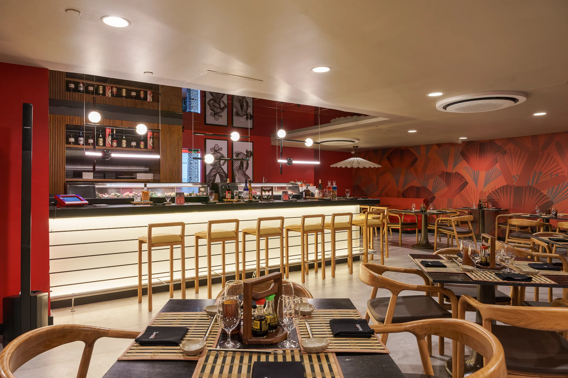 Interior de restaurante moderno con barra y asientos de madera.