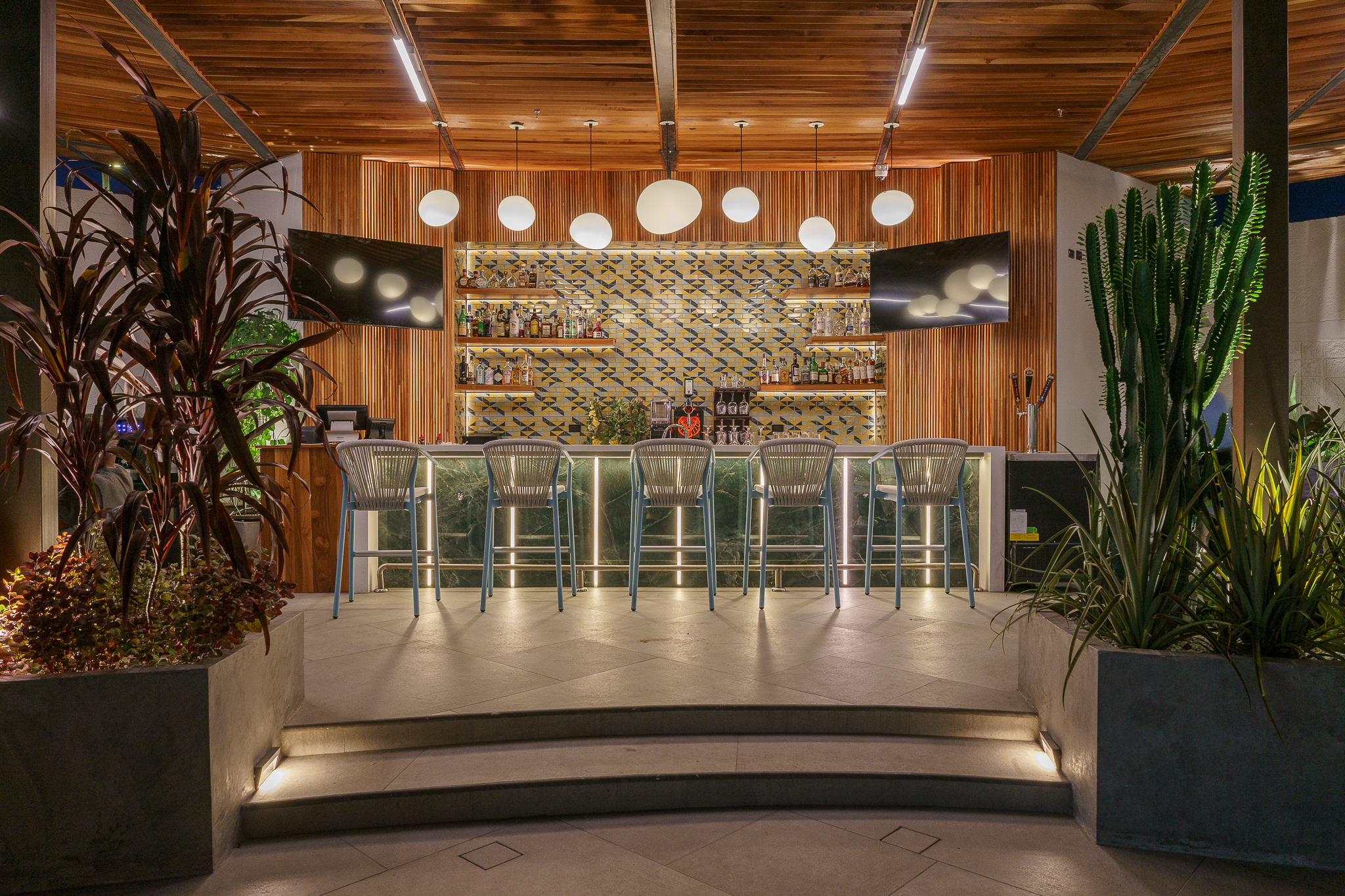 Bar con iluminación suave y decoración de madera en ambiente contemporáneo.
