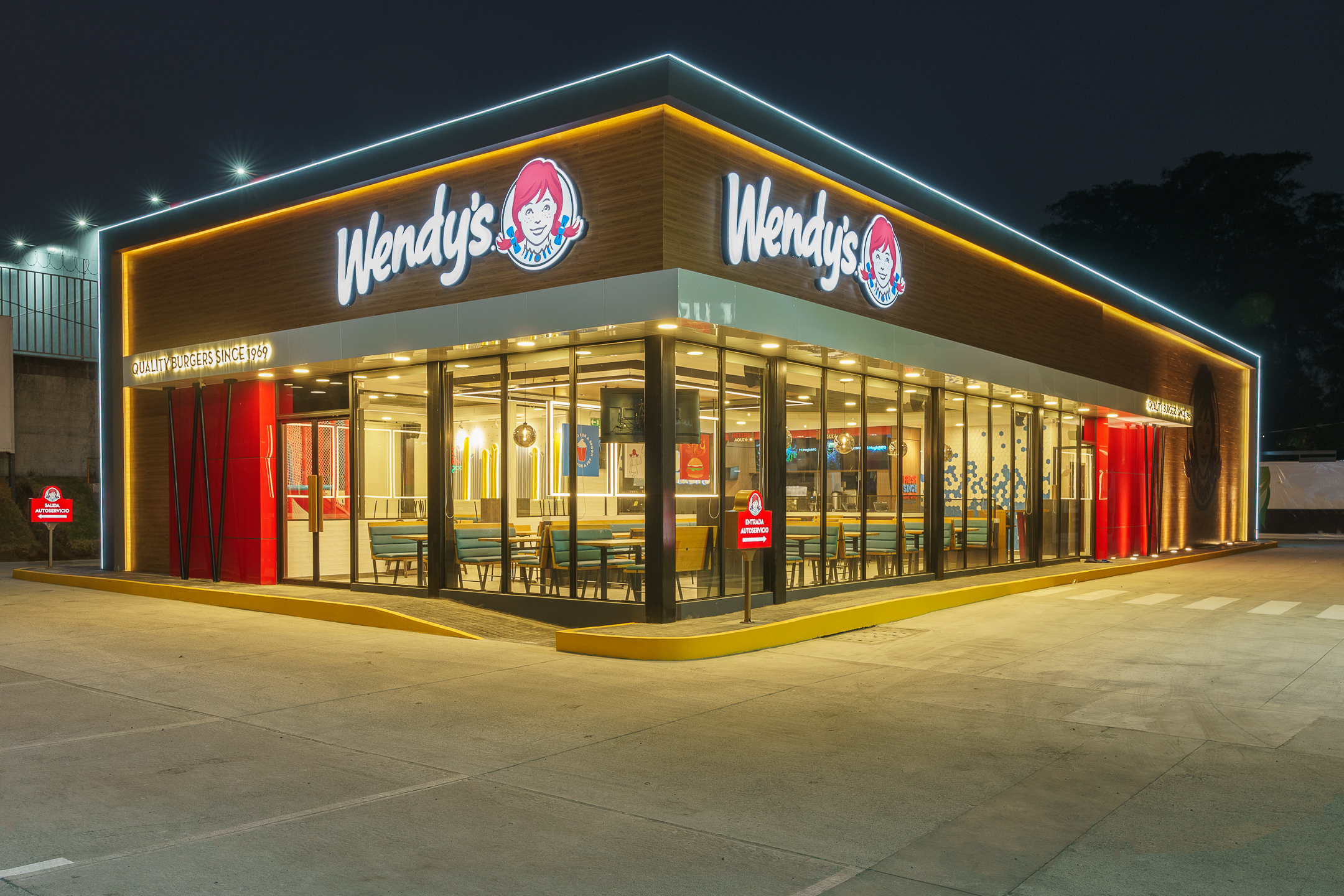 Fachada iluminada de restaurante Wendy's en Plaza Venecia, San Salvador.