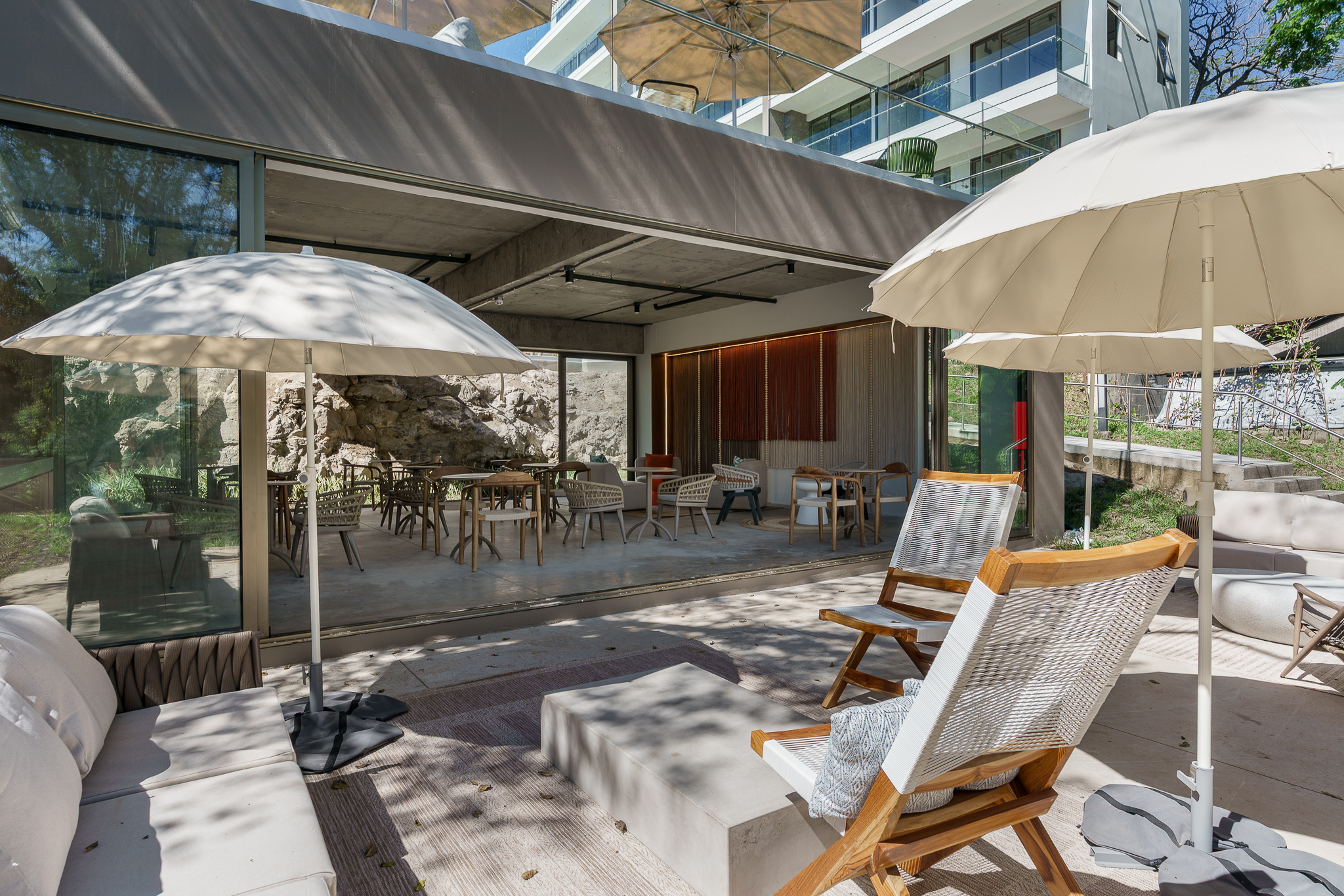 Modern terrace with outdoor furniture and parasols in a natural setting.