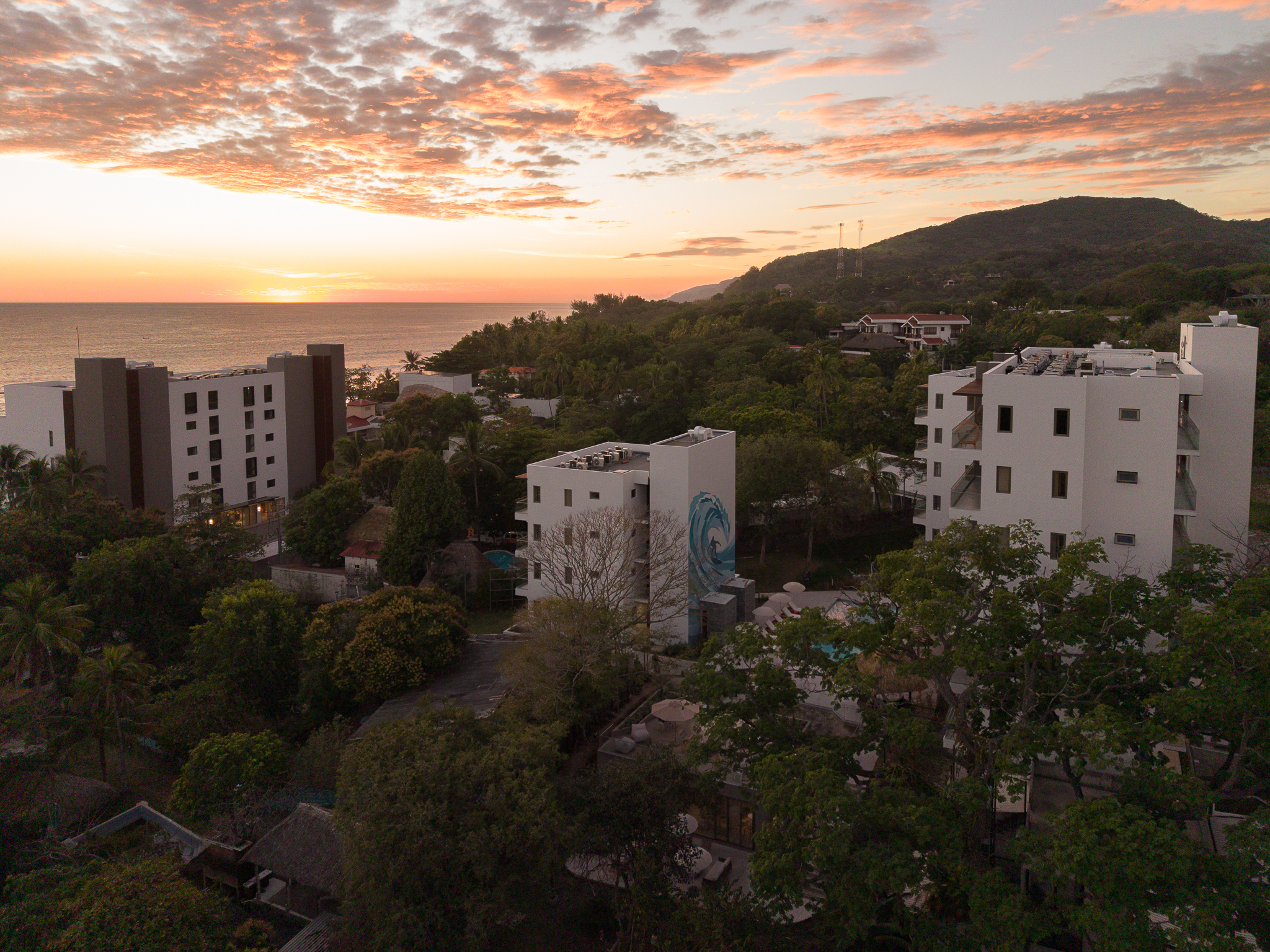 Vista aérea de residencias frente al mar al atardecer en Playa El Zonte, El Salvador.