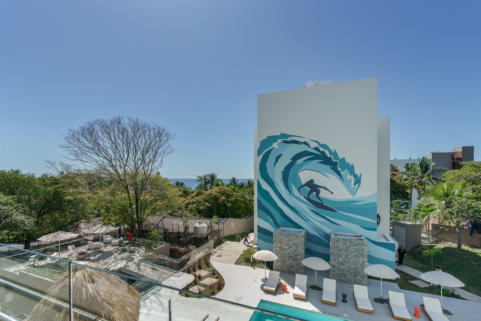 Building facade with a surfer mural and ocean view at El Zonte Beach.