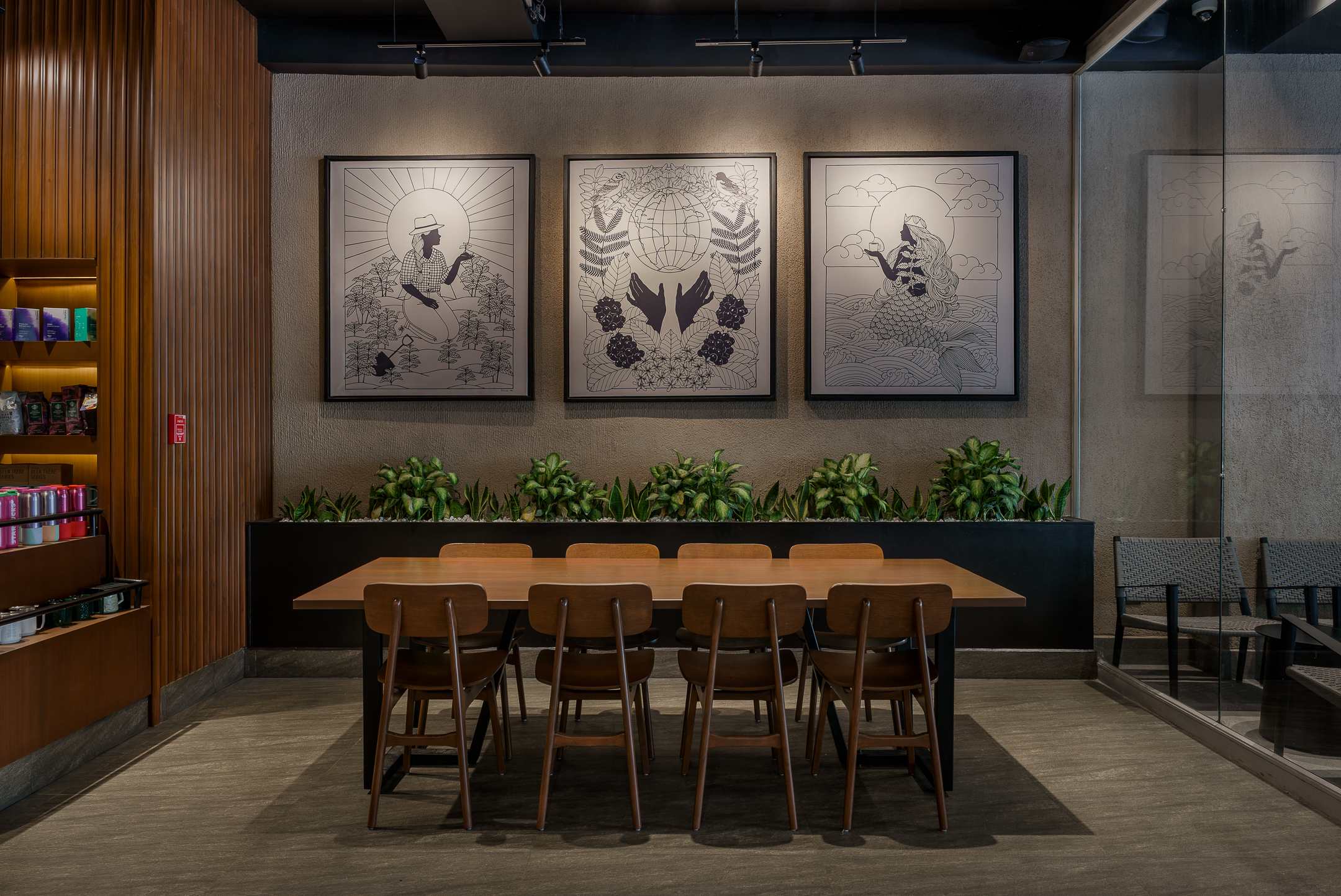 Mesa de reunión en cafetería Starbucks con arte en las paredes, El Salvador.