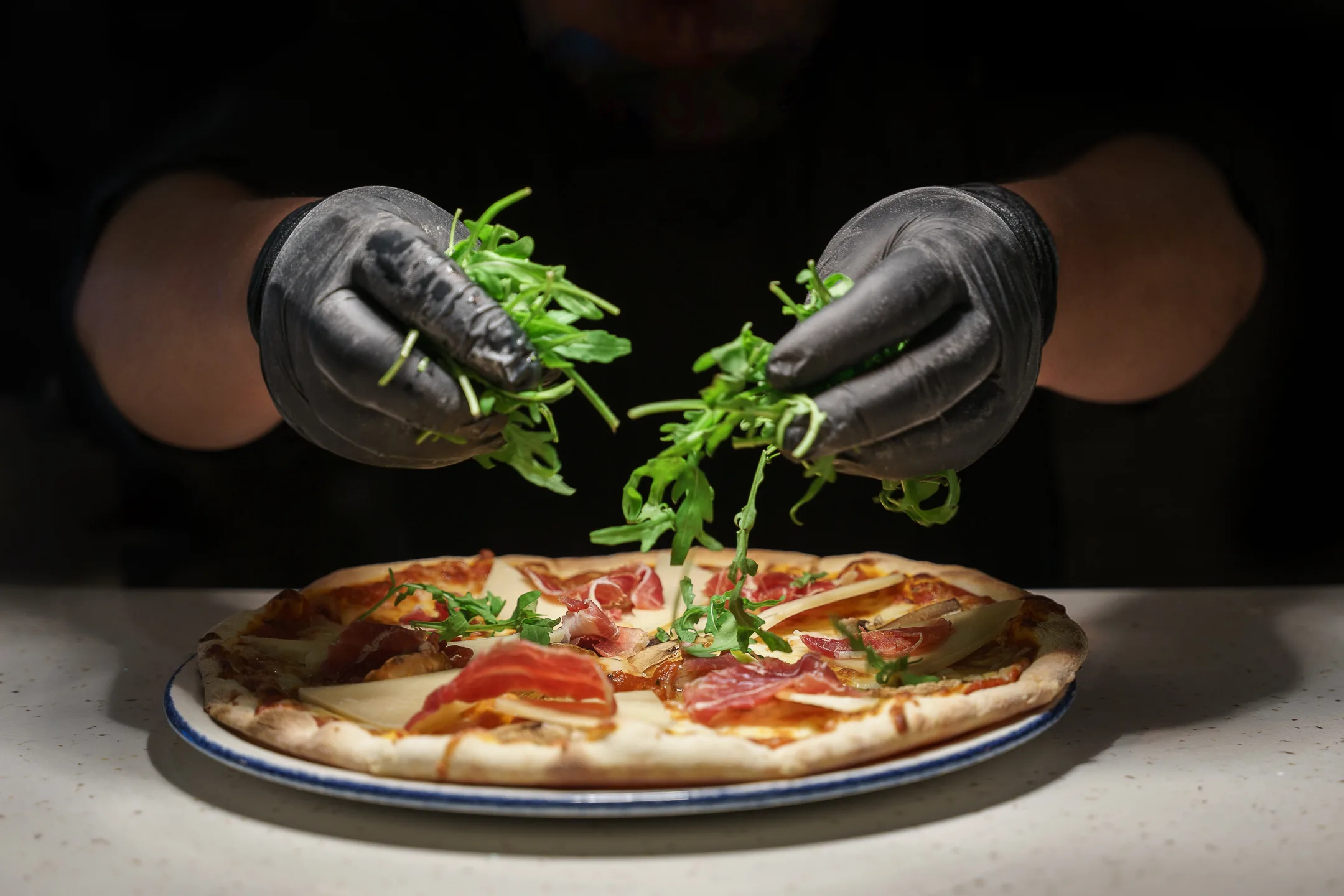 Chef preparing pizza during a commercial food production with food styling in El Salvador